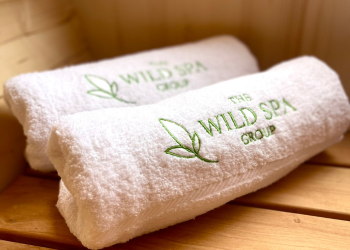 Wild Spa Group towels placed on bench inside sauna