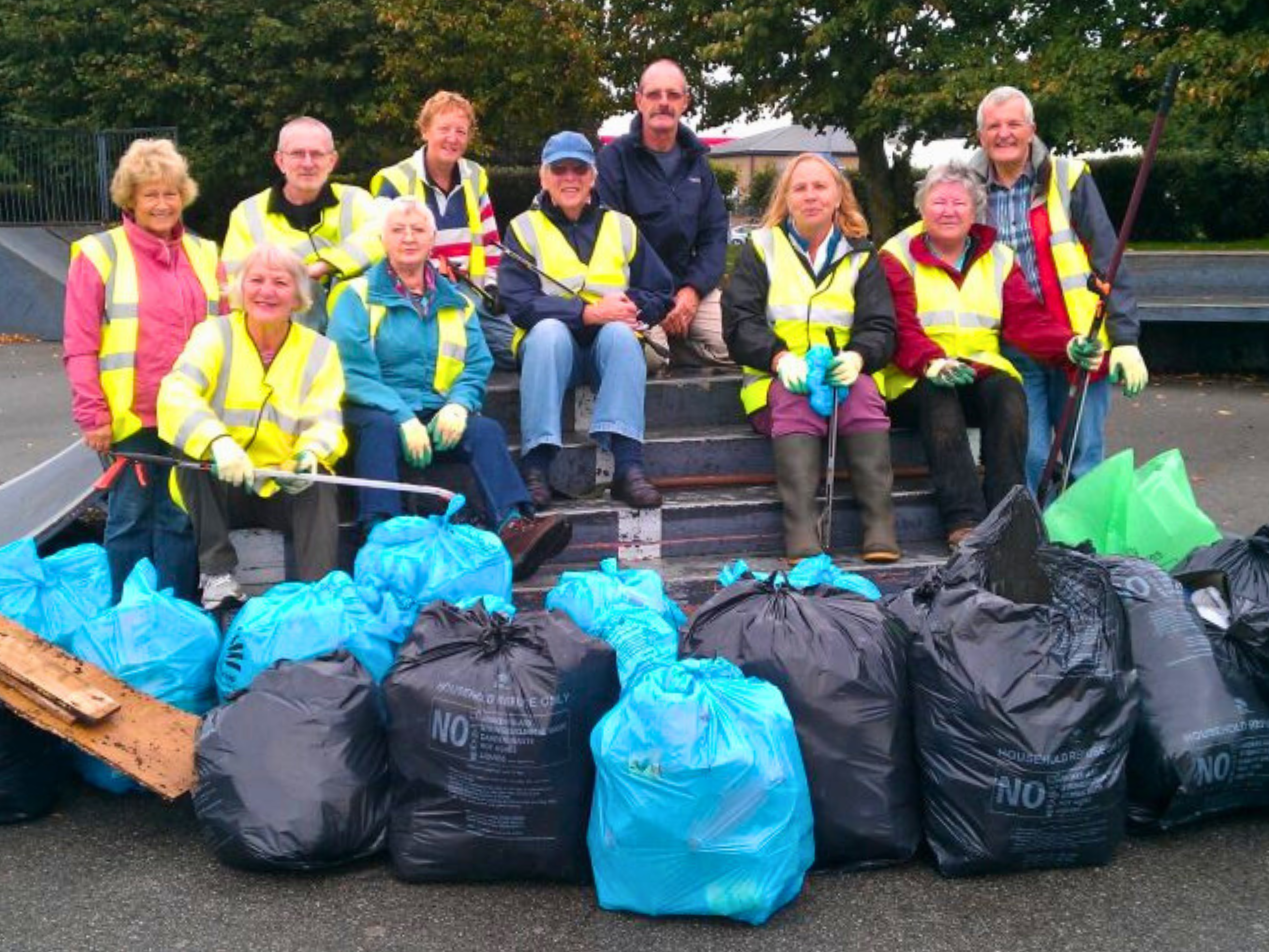 Community volunteers from Hilltop Litter Pickers show bags of litter collected during a pick.